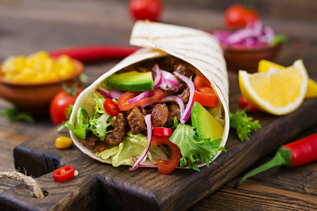 Mexican tacos with beef in tomato sauce and avocado salsa